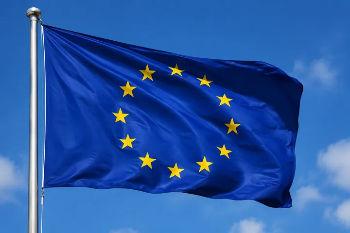 Flagge der Europäischen Union, die an einem Mast vor blauem Himmel weht