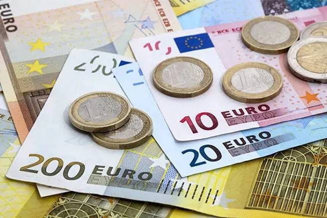 Eurové bankovky a mince rozložené na sobě — odměňování Head of AI v ČR a v zahraničí